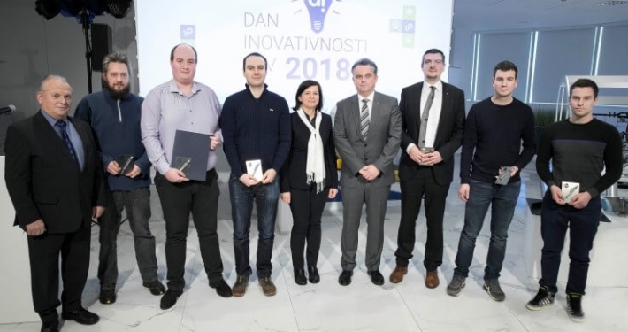 A lineup standing at the podium and posing for a photo at the Martin Sever Award presentation at TPV day of innovation 2018